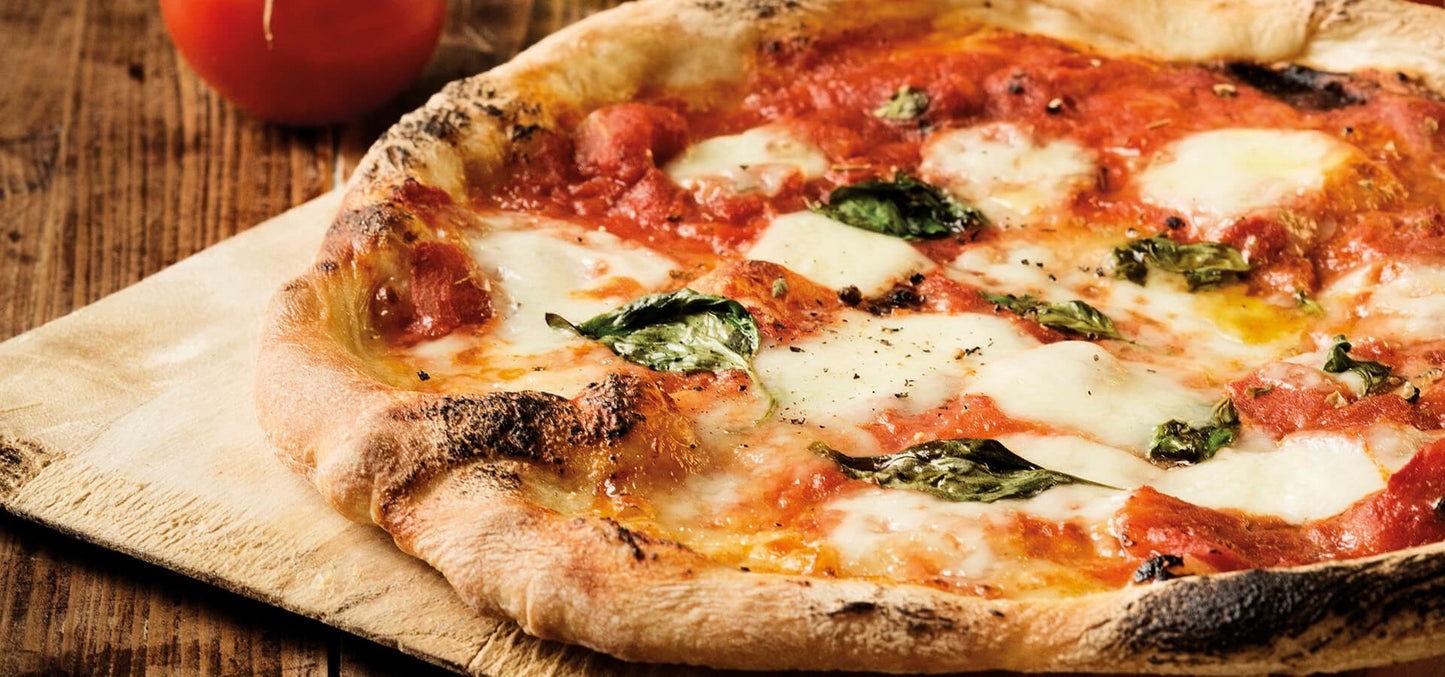 Margherita pizza with tomato and basil on a wooden board